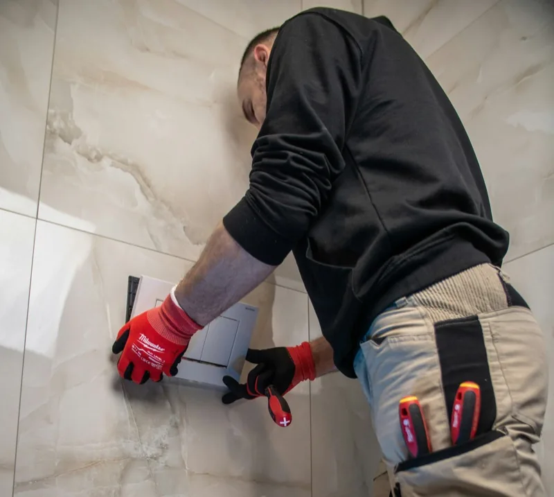 Plumber installing pipework on site