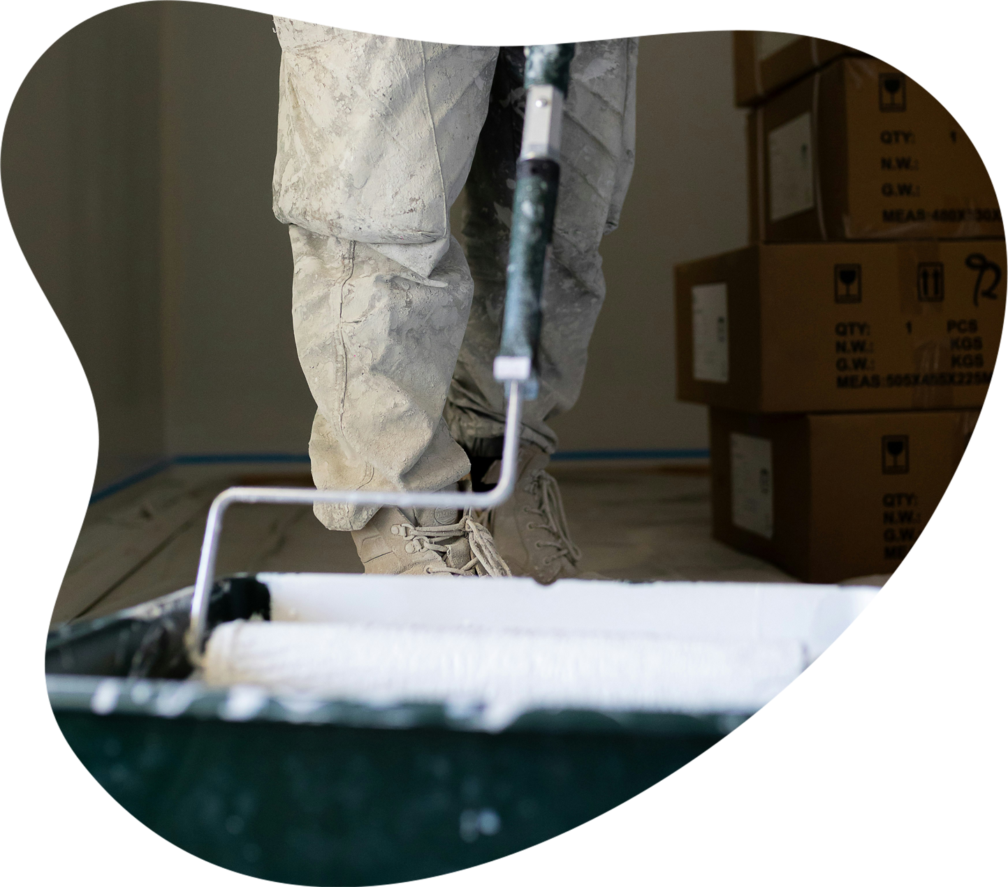 Painter using a roller with a paint tray on site