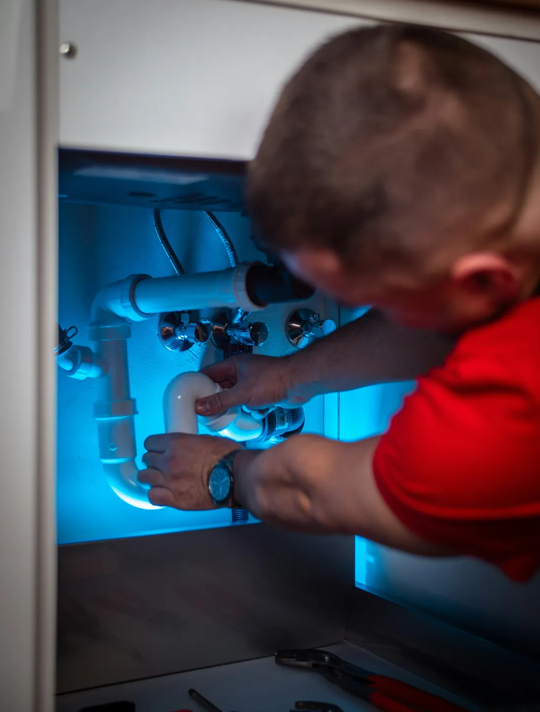 Plumber working under a sink